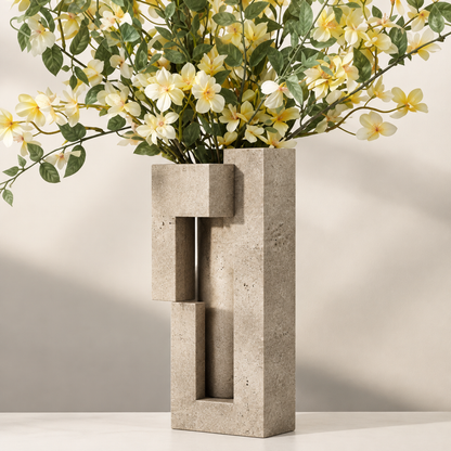 PLIOXOO® travertine vase top-down angle view on stone surface with plant leaves – Thoughtful Details: Beauty in Every Angle, showing internal interlocking rectangular channels
