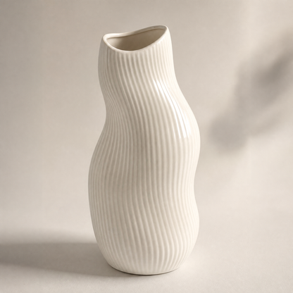 PLIOXOO® wave ribbed ceramic vase on warm beige background – full product view showing smooth matte white finish and undulating organic silhouette